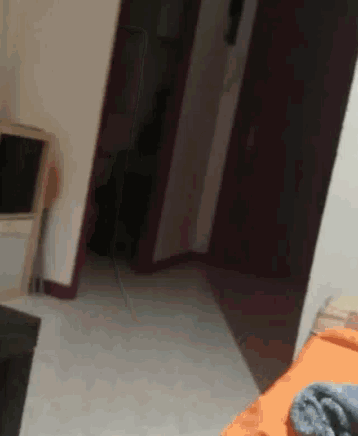 a person is walking through a doorway in a room with a bed .