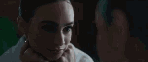 a woman is smiling at herself in a mirror .
