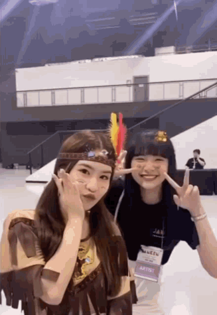 two girls pose for a picture with one wearing a lanyard that says artist