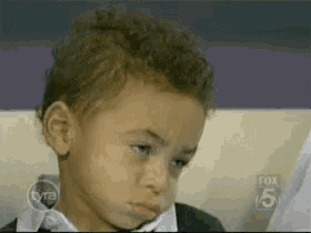 a young boy is sitting in front of a fox 5 news screen