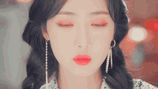 a close up of a woman 's face with her eyes closed and red lipstick
