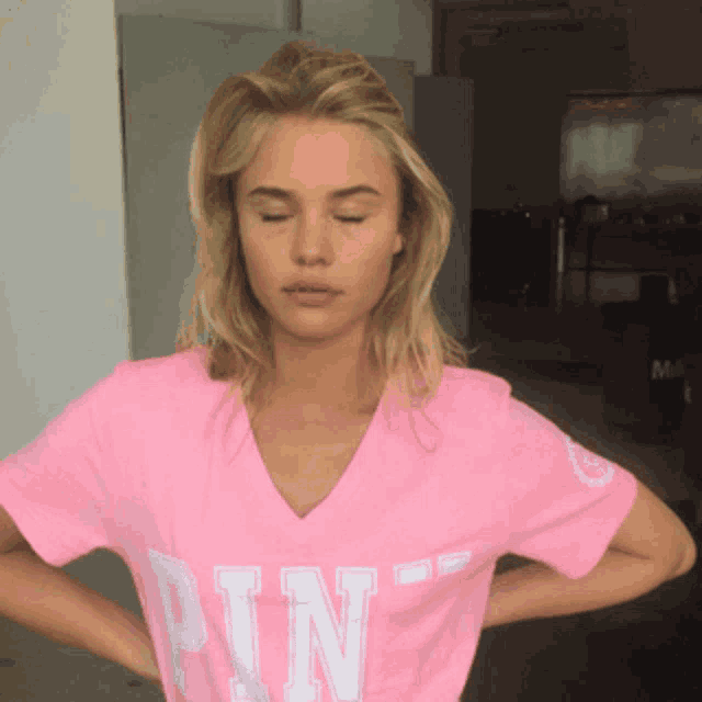 a woman wearing a pink t-shirt with the letter n on it