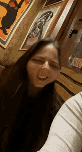 a woman is making a funny face in front of a monkey poster on the wall