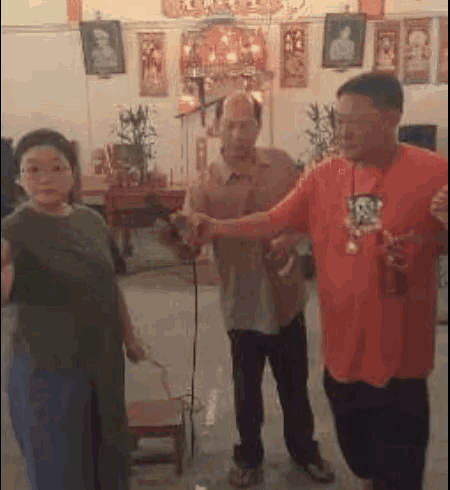 a group of people are standing in a room with a microphone .
