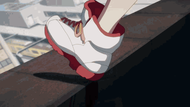 a person wearing a pair of white and red shoes is walking on a ledge