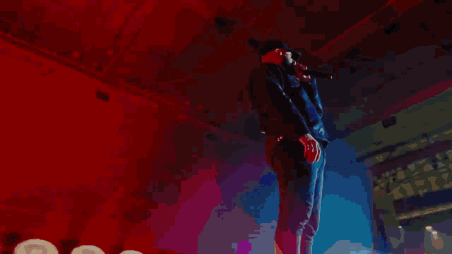 a man singing into a microphone while wearing a hat that says ' i am a rapper ' on it