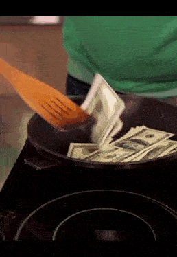 a person is cooking money in a pan with a wooden spatula