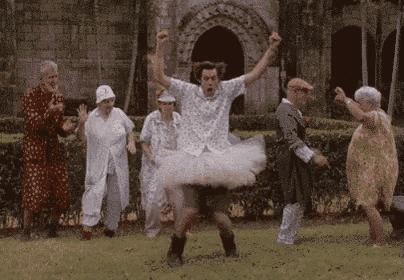 a group of elderly people are dancing in a park .
