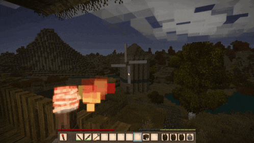 a screenshot of a minecraft game with a windmill in the distance