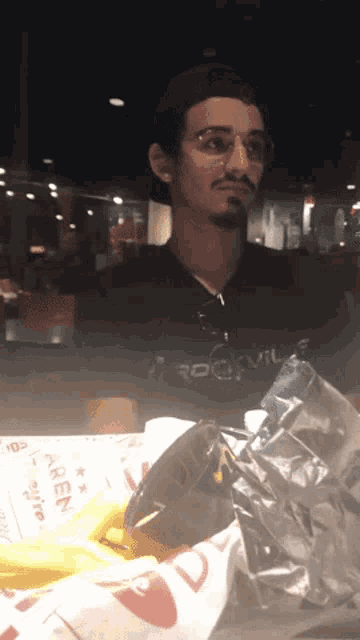 a man sitting at a table with a rockville shirt on