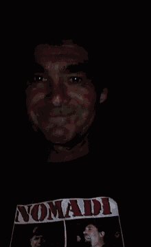 a man wearing a nomad shirt is sweating in a dark room