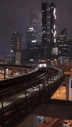 a train going through a city at night with the word siemens in the background