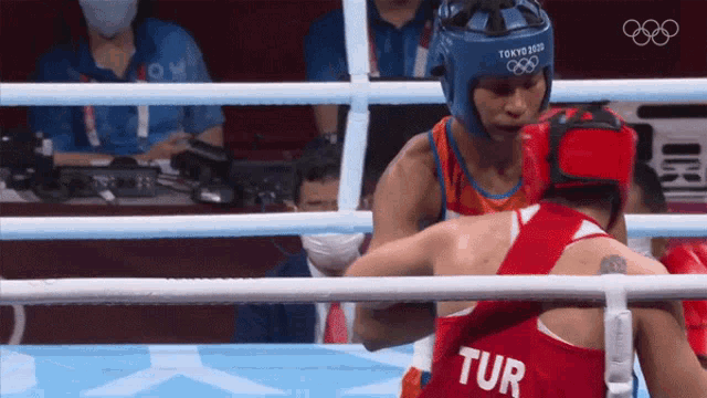 two boxers in a ring one of whom is wearing a tur jersey