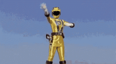 a yellow power ranger with the number 3 on his chest is standing in the rain with his hands in the air .