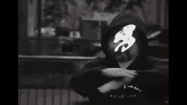 a black and white photo of a person wearing a hooded sweatshirt with the word canada written on it .