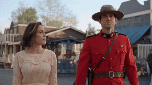 a man in a red uniform is walking with a woman