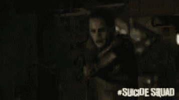 a man is standing in front of a drum set with the words suicide squad on the bottom
