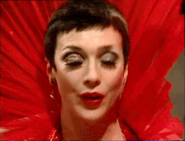 a close up of a woman 's face wearing a red dress and a red fan .