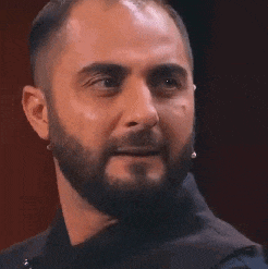 a close up of a man with a beard and microphone in his ear .