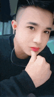 a close up of a young man 's face with a finger on his chin