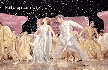 a man and a woman are dancing in front of a crowd of people on a stage .