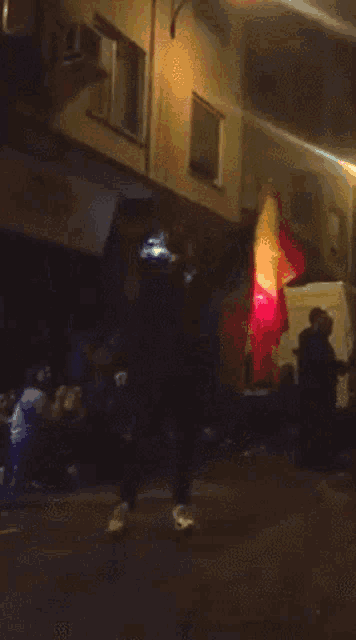 a group of people standing in front of a building with a red light behind them