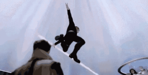 a man is doing a trick on a skateboard in the air while another man watches .