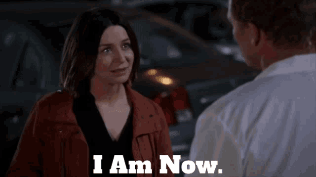 a man and a woman are standing next to each other and the woman says " i am now "