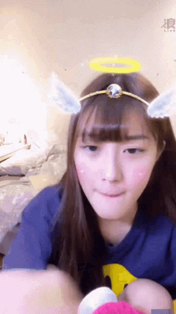 a girl wearing a headband with angel wings and a halo on her head