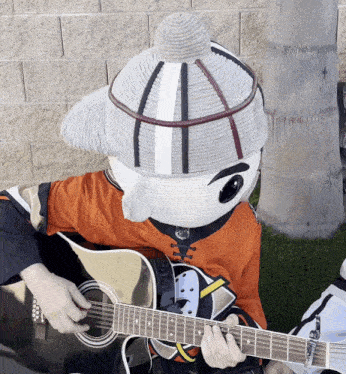 a mascot is playing a guitar and wearing a hockey jersey