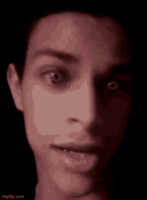 a close up of a man 's face with his mouth open and his eyes looking at the camera .