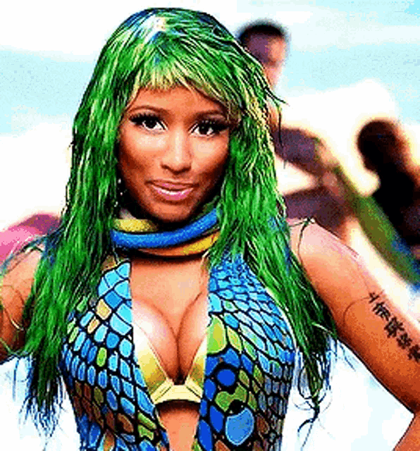a woman with green hair and a tattoo on her arm is wearing a blue and yellow swimsuit .