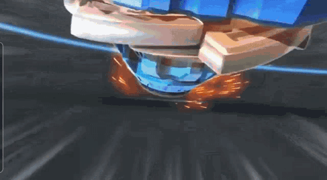 a blue and gold toy is spinning on a black surface .