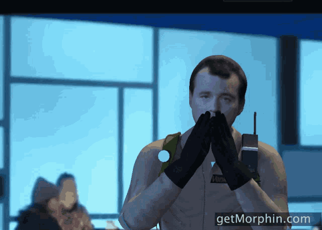 a man in a ghostbusters costume has his hands on his face