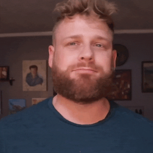 a man with a beard says that 's nice in a blue shirt