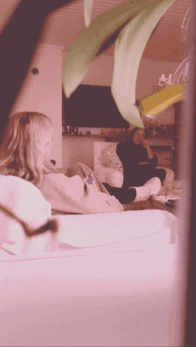 a woman sits on a couch while another woman sits on a chair