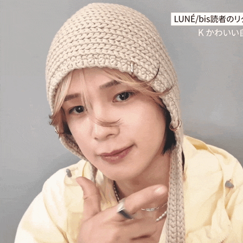 a person wearing a knitted hat with the word lune on the top