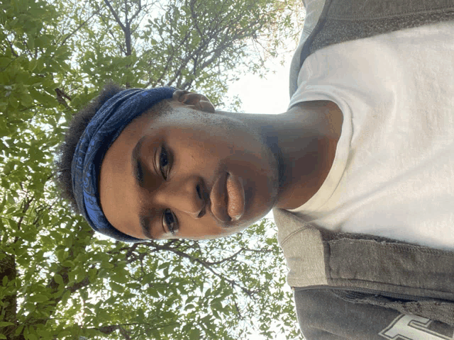 a young man wearing a bandana and a jacket with the letter f on the sleeve