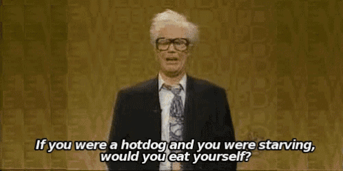 a man in a suit and tie is giving a speech and talking about a hotdog .