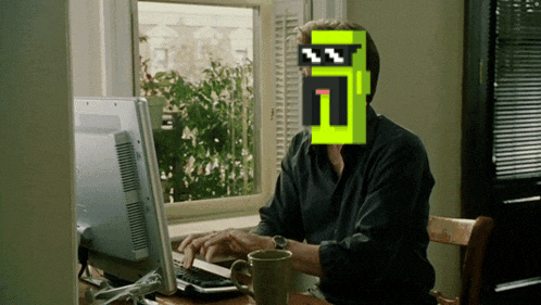 a man sitting in front of a computer with a pixelated face that says ' n ' on it