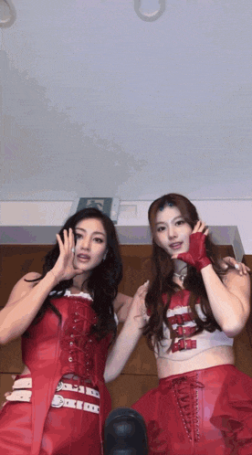 two women in red outfits are posing for a picture