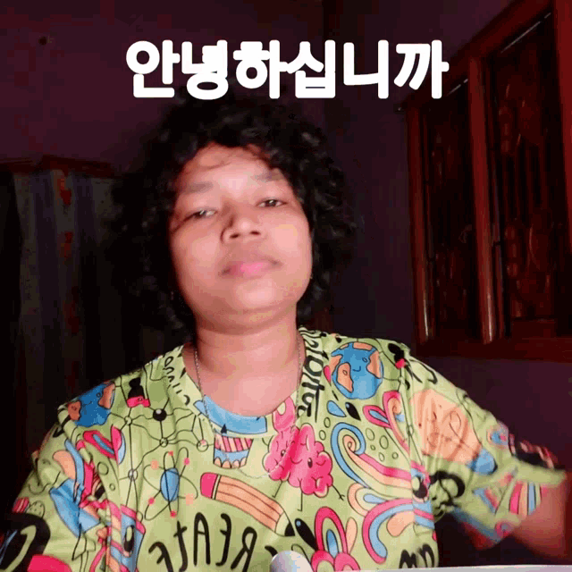 a woman wearing a colorful shirt has a foreign language written above her