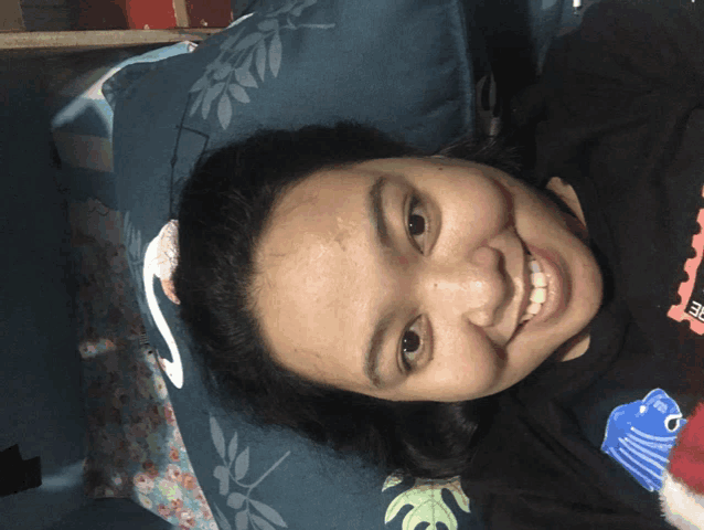 a woman is smiling while laying on a bed with a swan pillow