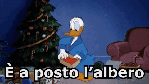 donald duck sitting in front of a christmas tree with the words " e a posto l' albero " below him