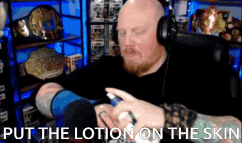 a bald man wearing headphones is putting lotion on his arm