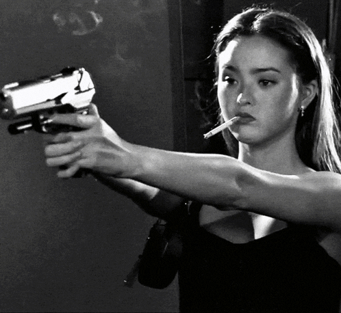 a woman is smoking a cigarette and pointing a gun