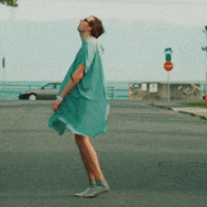a person in a green dress is standing on a street
