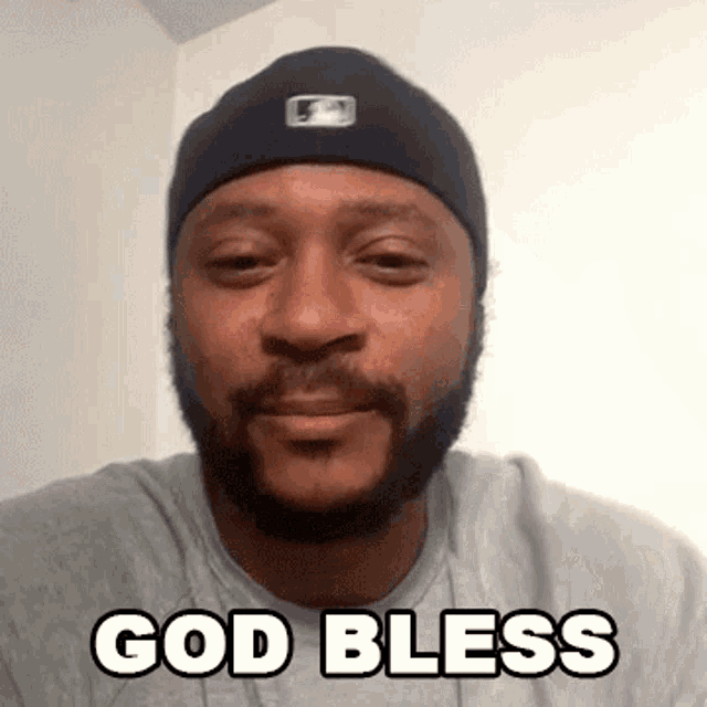 a man with a beard wearing a hat and a t-shirt says god bless