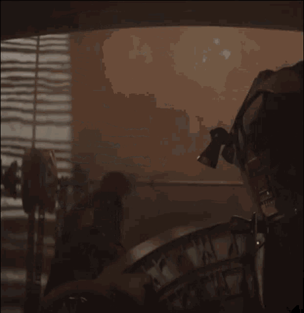 a person playing a drum in a dark room with a shadow on the wall