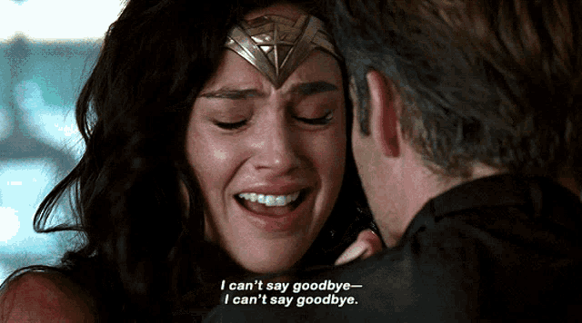 a woman in a wonder woman costume is crying while a man says goodbye